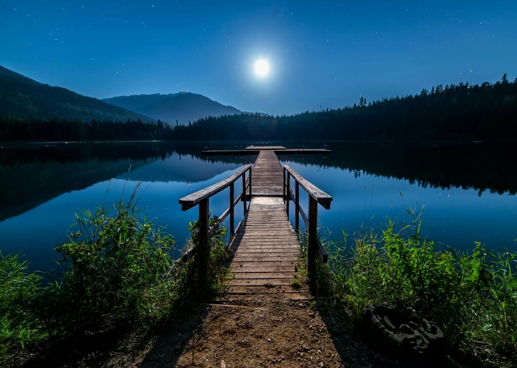 soleil au clair de lune entre les montages et un pont qui part vers un ailleurs un avenir serein 